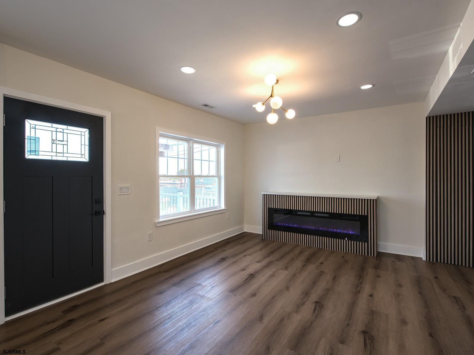 706 Augustine Road Atlantic City, NJ 08401 - Photo 8 of 56 an empty room with wooden floor chandelier and windows