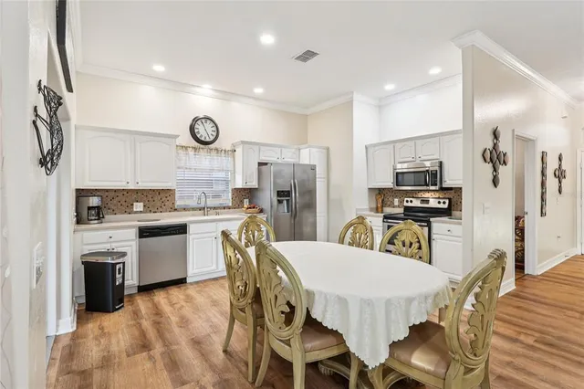 a kitchen with stainless steel appliances a stove and white cabinets