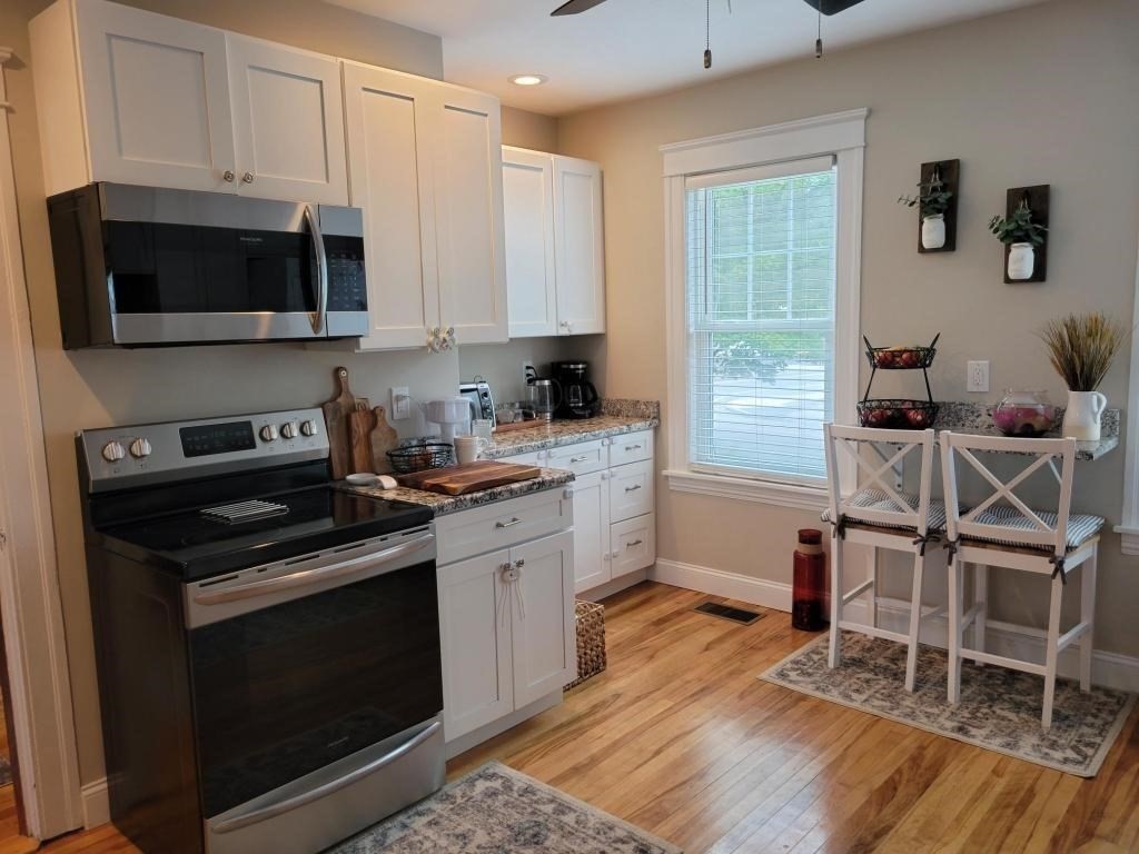 352 Chandler Street, Unit 1 Worcester, MA 01602 - Photo 2 of 23 a kitchen with a stove a sink and a microwave