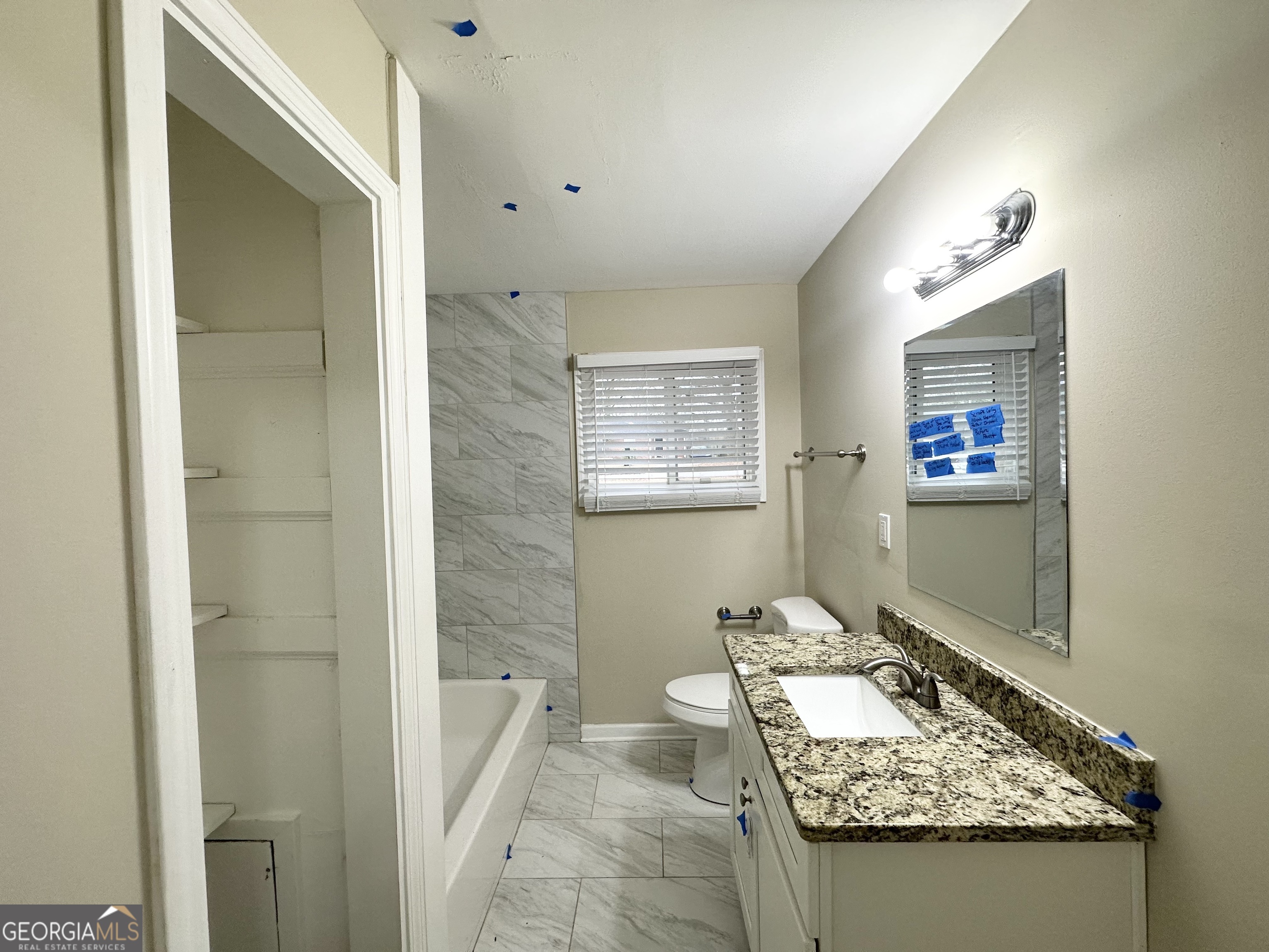 2310 Ousley Court Decatur, GA 30032 - Photo 10 of 11 a bathroom with a granite countertop sink a toilet a mirror and shower