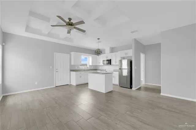 a view of a kitchen with wooden floor and electronic appliances