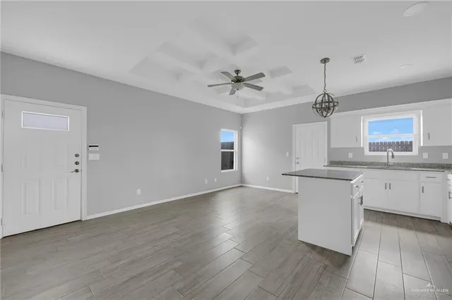 a view of a kitchen with a sink a kitchen island with wooden floor and a kitchen