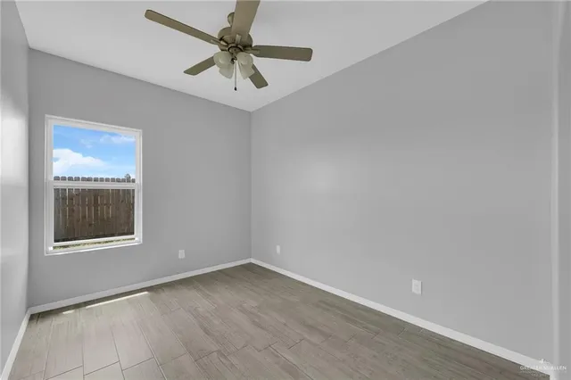 an empty room with a window and a fan