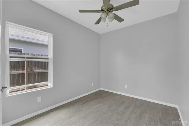 an empty room with a window and a fan