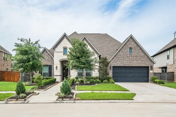 a front view of a house with a garden and plants