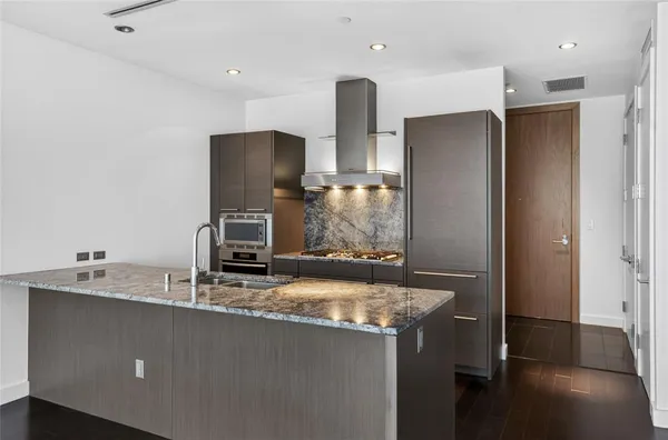 a kitchen with stainless steel appliances granite countertop a refrigerator and a sink