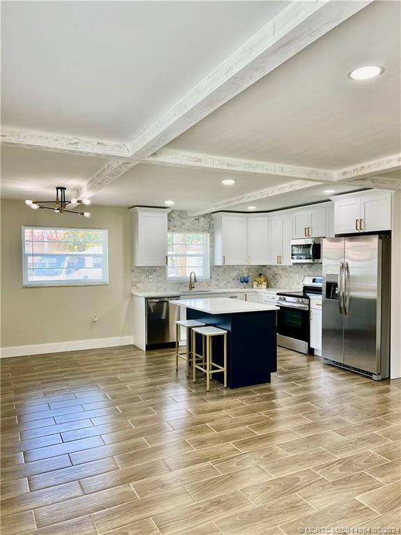 a large kitchen with stainless steel appliances granite countertop a large counter top a stove and cabinets