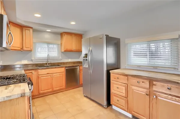 a kitchen with stainless steel appliances granite countertop a refrigerator and a stove top oven