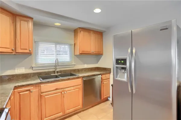 a kitchen with stainless steel appliances granite countertop cabinets and a refrigerator