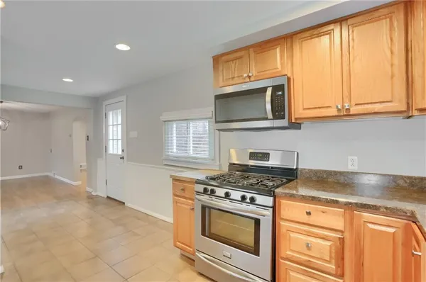 a kitchen with granite countertop cabinets stainless steel appliances and a window
