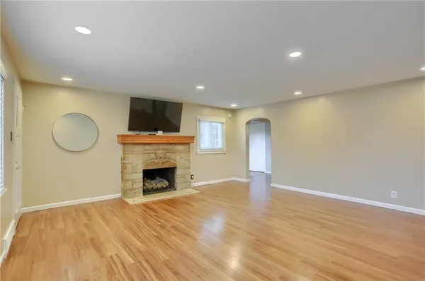 a view of empty room with wooden floor and fireplace