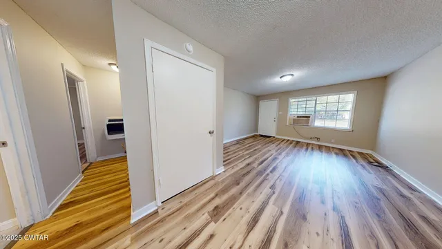 a view of a room with wooden floor staircase and a kitchen