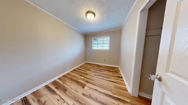 a view of a room with wooden floor and window