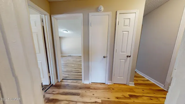 a view of a hallway with wooden floor and staircase