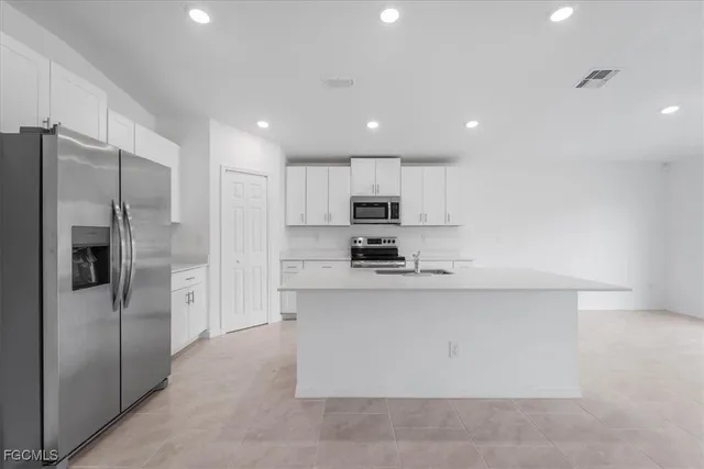 a kitchen with white cabinets sink and stove
