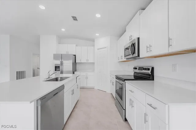 a kitchen with white cabinets and stainless steel appliances