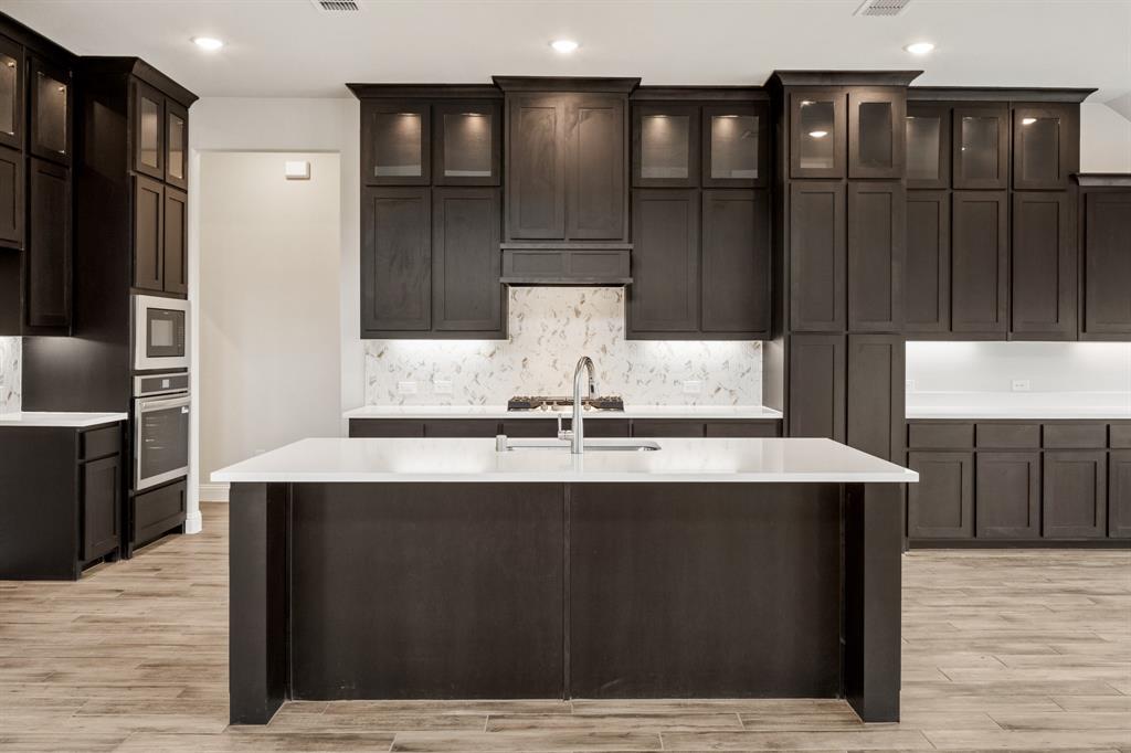 1630 Secco Way Rockwall, TX 75032 - Photo 15 of 40 a view of kitchen with stainless steel appliances granite countertop counter top space cabinets and wooden floor