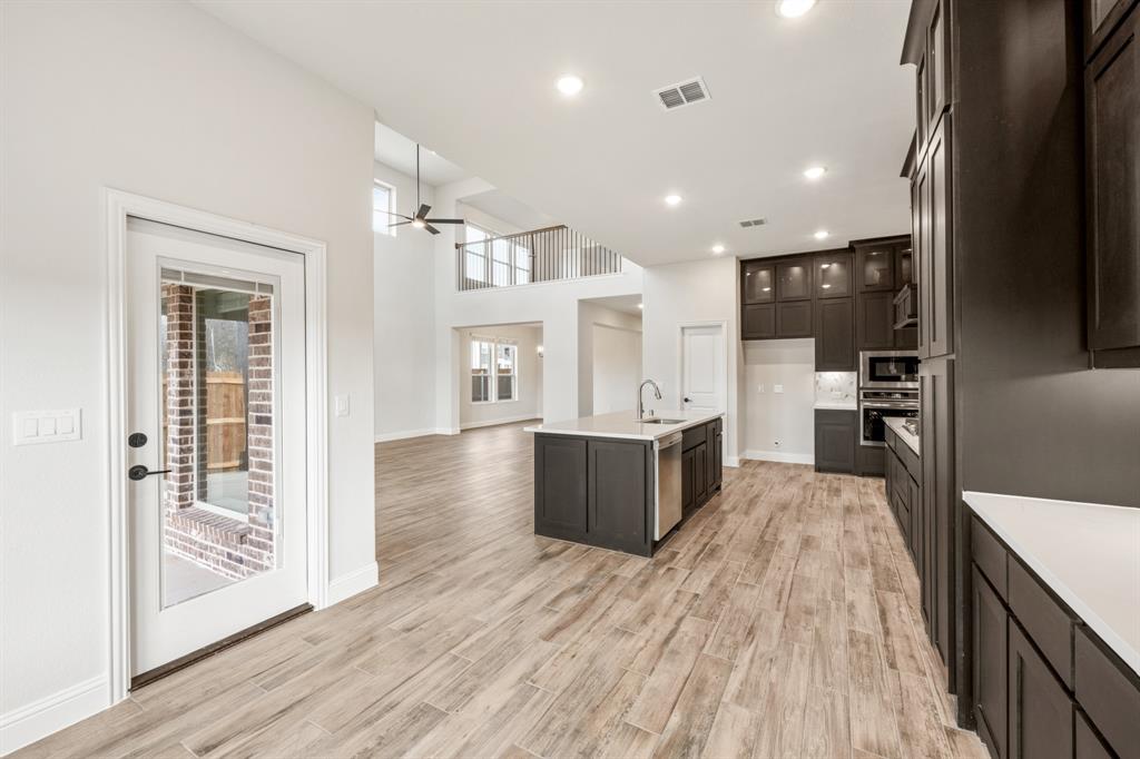 1630 Secco Way Rockwall, TX 75032 - Photo 18 of 40 a large kitchen with stainless steel appliances kitchen island granite countertop a large counter top and wooden floors