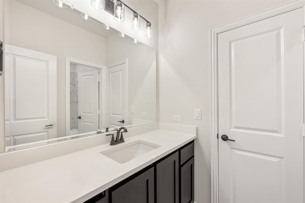 1630 Secco Way Rockwall, TX 75032 - Photo 33 of 40 a bathroom with a sink and a mirror