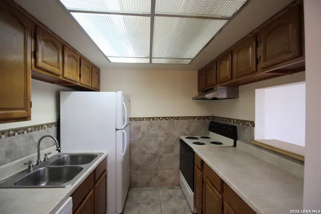 a kitchen with stainless steel appliances granite countertop a sink stove and cabinets