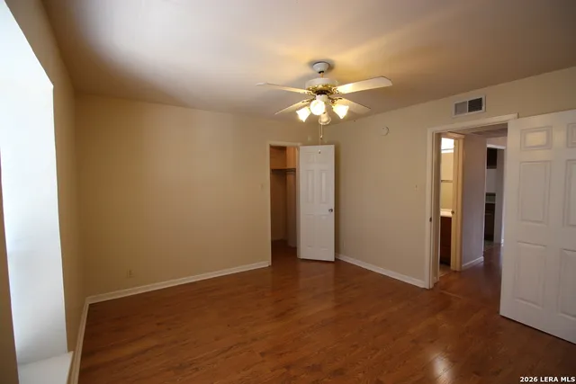 a view of an empty room with wooden floor