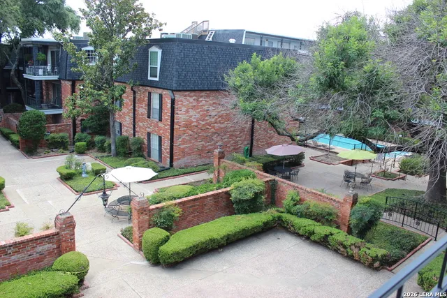 a backyard of a house with lots of green space and fountain