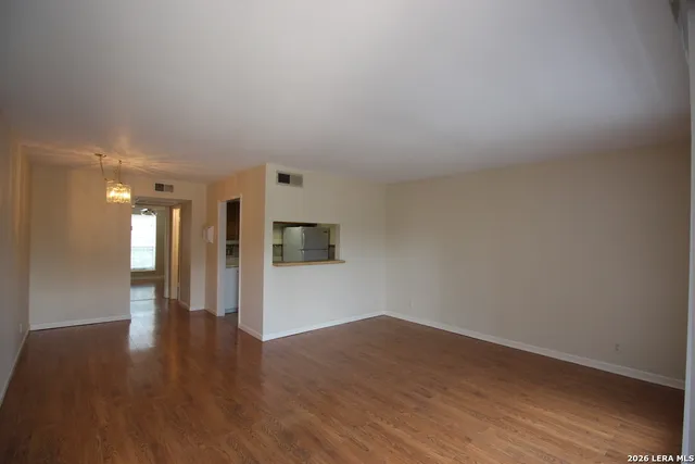 a view of empty room with wooden floor