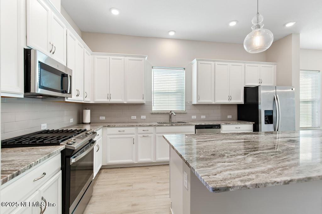92 Alston Drive St. Augustine, FL 32092 - Photo 19 of 53 a kitchen with stainless steel appliances granite countertop a stove a sink and a microwave