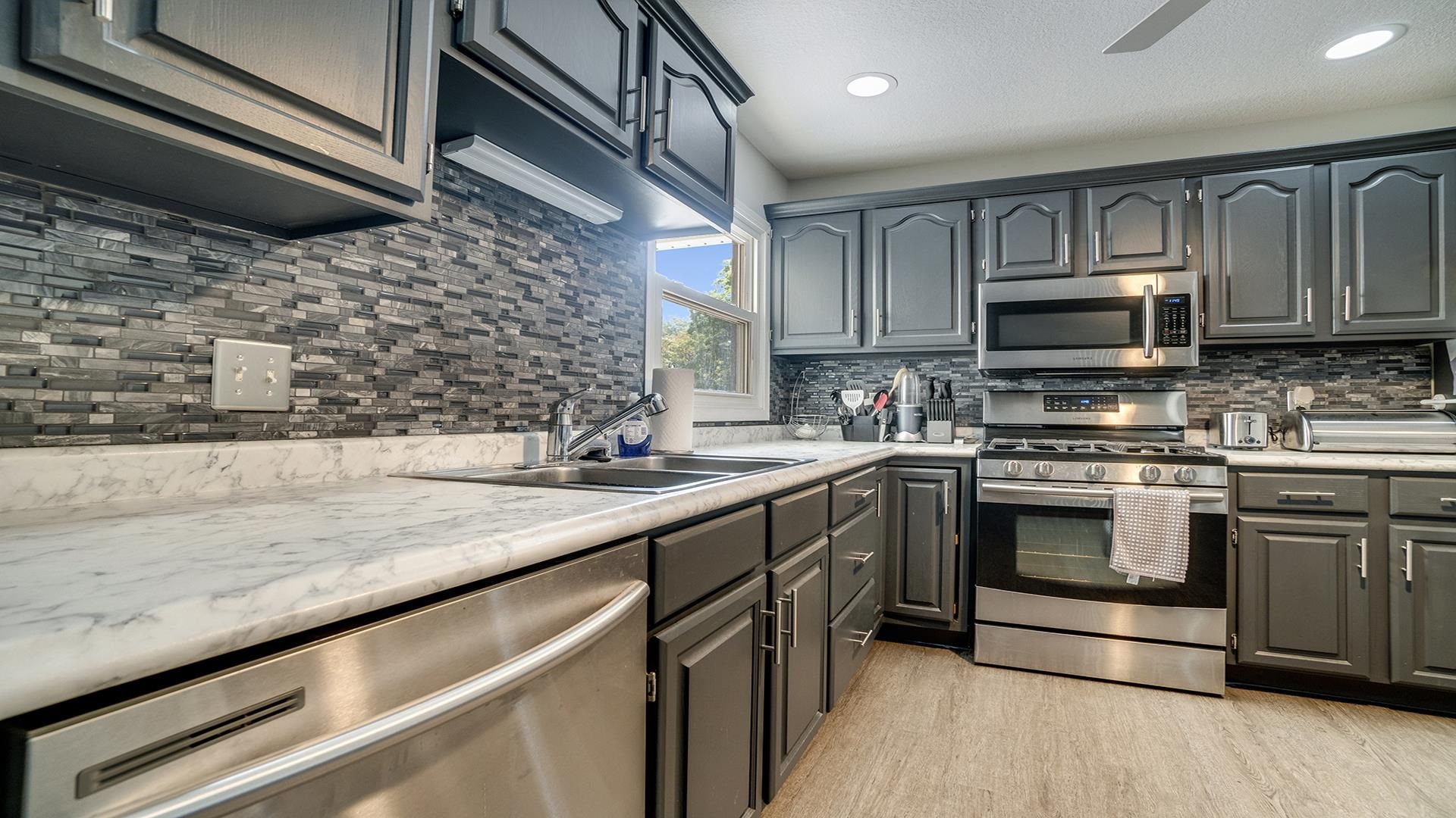 1065 Idle Oak Run Dixon, IL 61021 - Photo 33 of 44 a kitchen with stainless steel appliances granite countertop a sink a stove top oven and cabinets