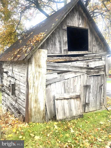 a view of backyard with wooden fence and a large tree