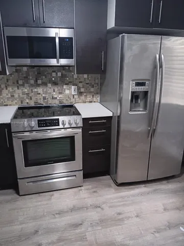 a kitchen with granite countertop a stove and a microwave oven