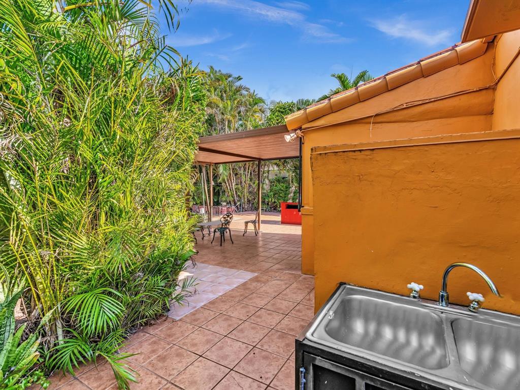 2347 Southwest 18th Street Miami, FL 33145 - Photo 30 of 46 a backyard of a house with table and chairs a barbeque with potted plants