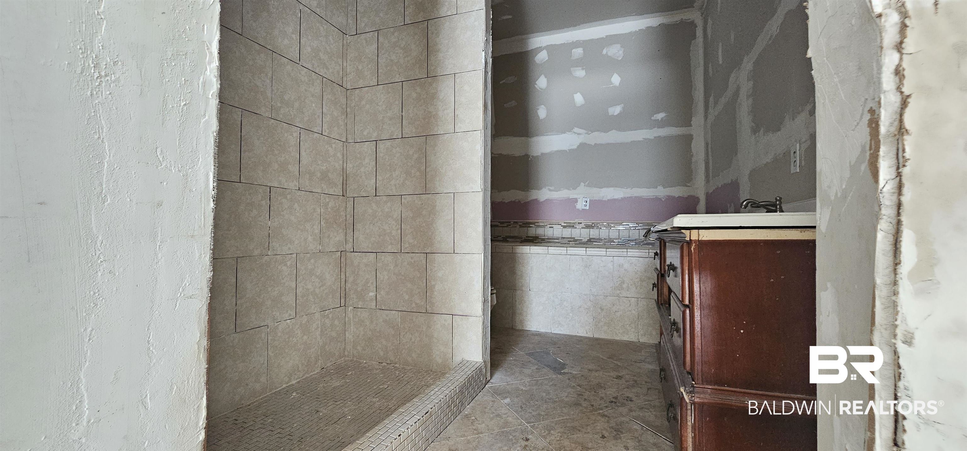 151 Bullard Street Atmore, AL 36502 - Photo 30 of 38 Bathroom with vanity, a shower stall, and tile walls