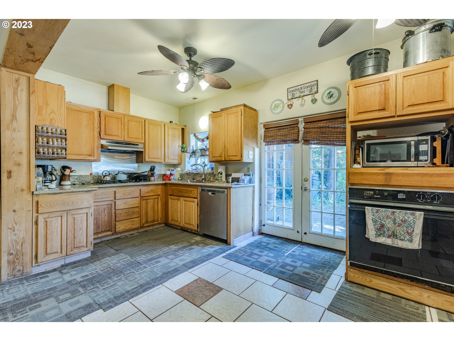 6585 Main Street Springfield, OR 97478 - Photo 18 of 30 a kitchen with stainless steel appliances granite countertop a refrigerator a sink dishwasher and white cabinets with wooden floor