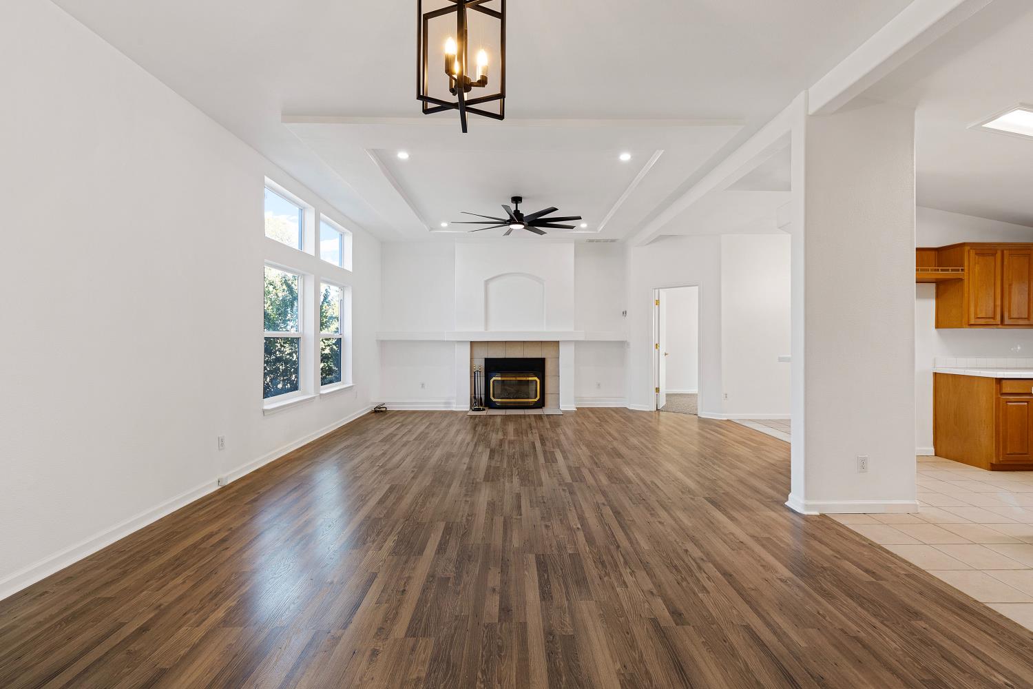 8181 West Kile Road Thornton, CA 95686 - Photo 11 of 65 an empty room with wooden floor fireplace and windows