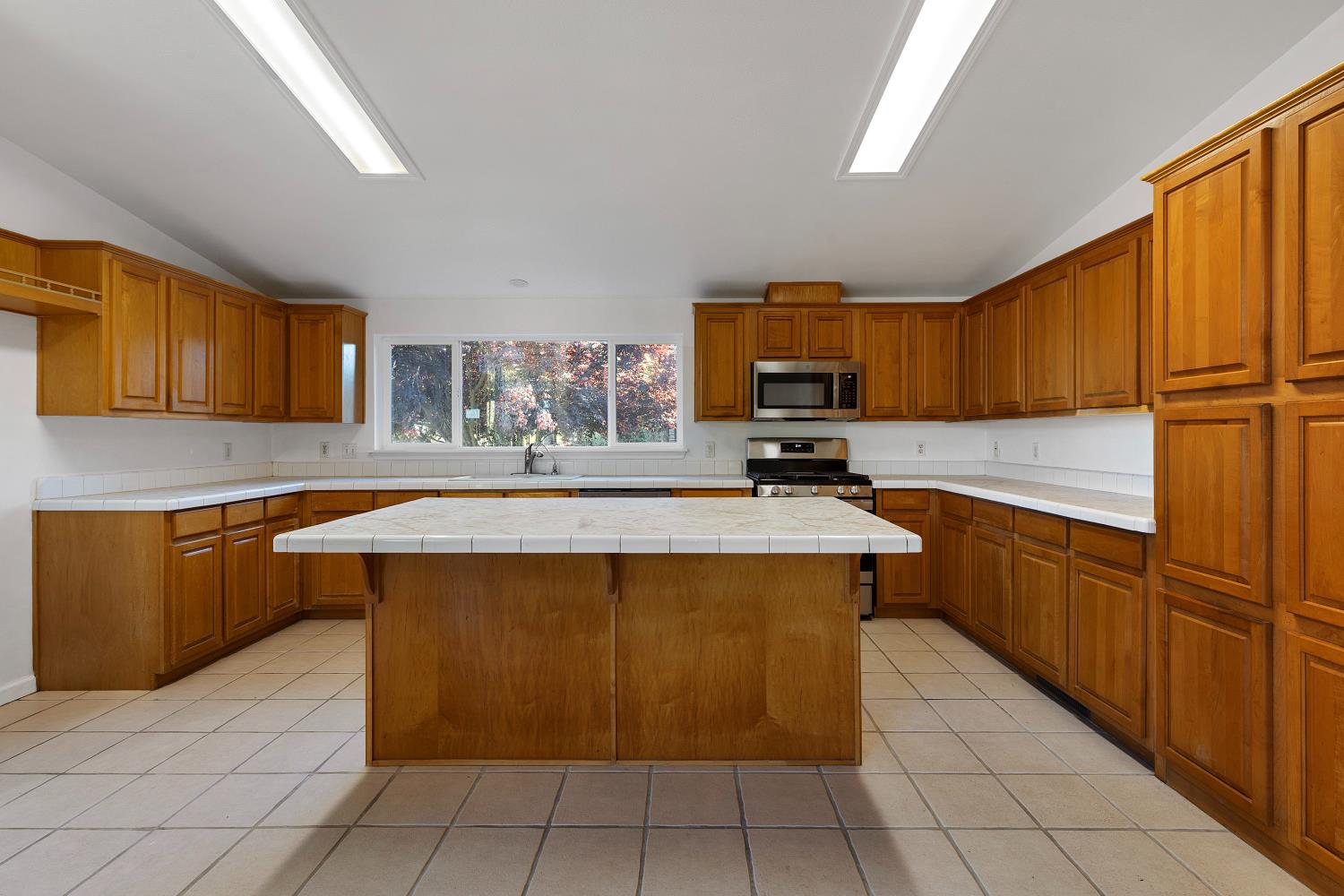 8181 West Kile Road Thornton, CA 95686 - Photo 14 of 65 a kitchen with stainless steel appliances granite countertop wooden cabinets a stove top oven a sink and dishwasher