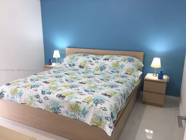 a large bed sitting in a bedroom and a lamp