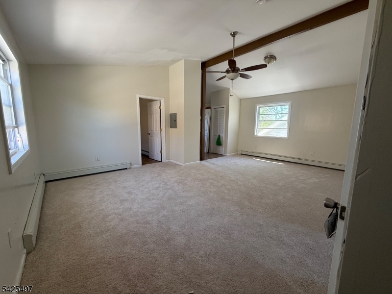 74 Spring Street Bloomfield, NJ 07003 - Photo 7 of 9 an empty room with windows and a ceiling fan