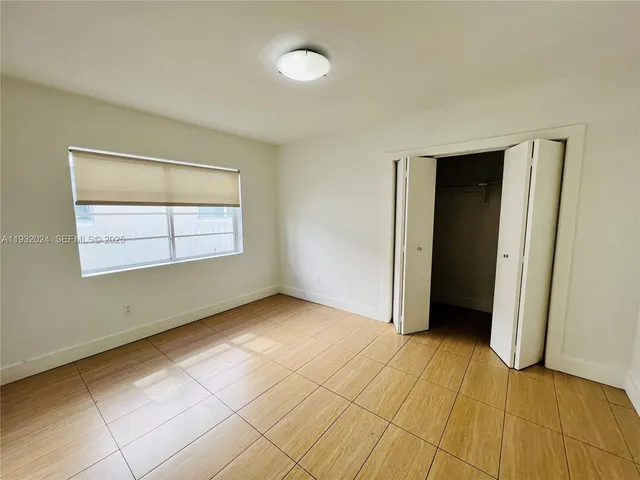 an empty room with windows and closet