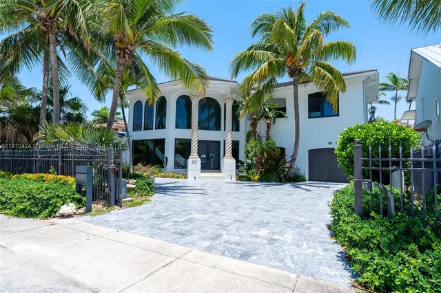 a view of a house with a yard and palm trees