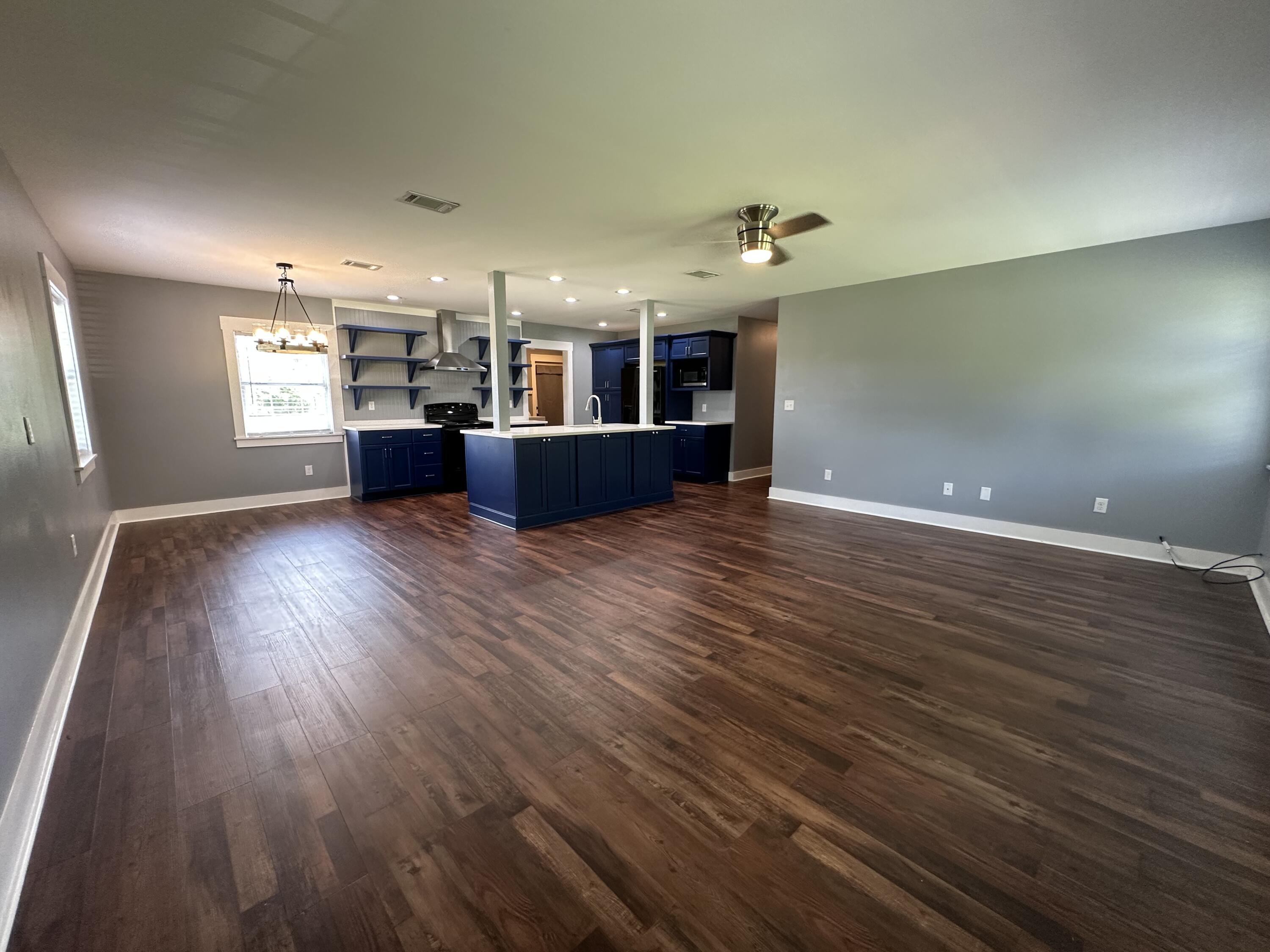 10712 Highway 331 DeFuniak Springs, FL 32433 - Photo 19 of 56 a view of a living room a kitchen and a wooden floor