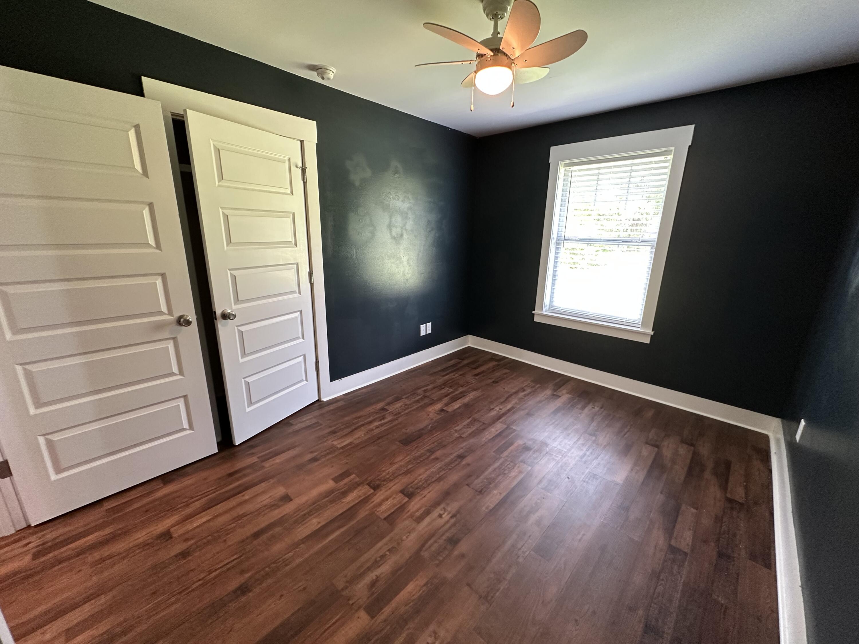 10712 Highway 331 DeFuniak Springs, FL 32433 - Photo 40 of 56 an empty room with wooden floor fan and windows