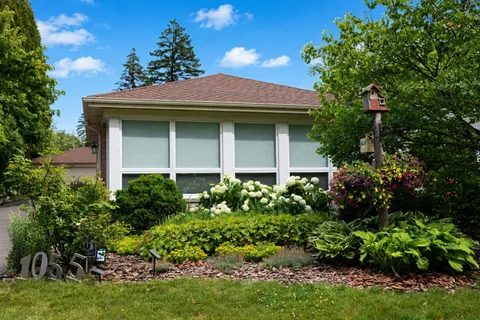 a view of a house with lots of plants and a flower plant