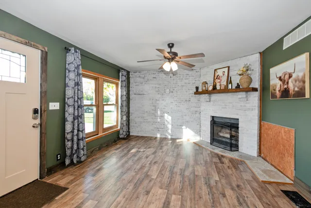 wooden floor fireplace and windows in an empty room