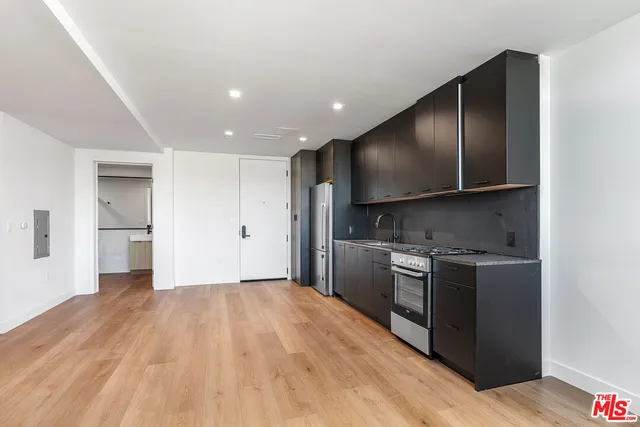 a kitchen with stainless steel appliances granite countertop a refrigerator and a stove top oven