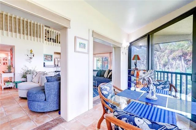 a kitchen with stainless steel appliances granite countertop a stove top oven a sink a dining table and chairs with wooden floor