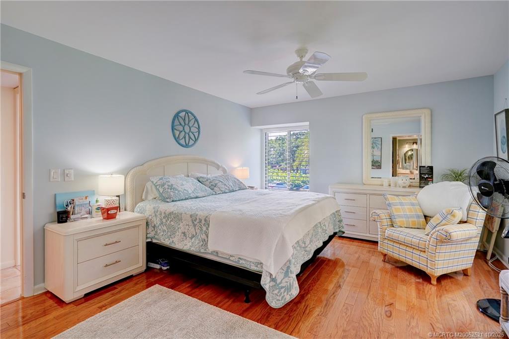 233 Northeast Edgewater Drive, Unit 201 Stuart, FL 34996 - Photo 35 of 64 a bedroom with a bed and wooden floor