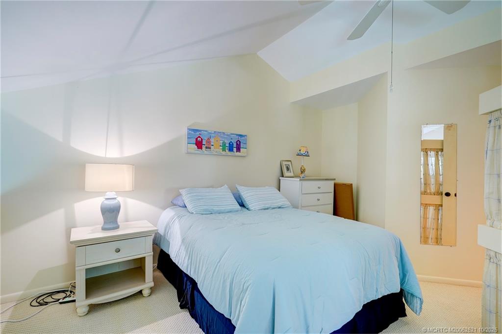 233 Northeast Edgewater Drive, Unit 201 Stuart, FL 34996 - Photo 46 of 64 a bedroom with a bed and a table