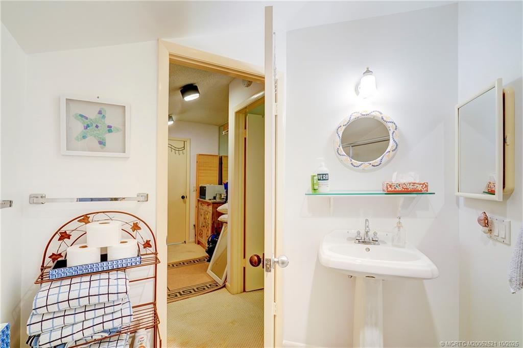 233 Northeast Edgewater Drive, Unit 201 Stuart, FL 34996 - Photo 51 of 64 a bathroom with a sink a mirror and a shower