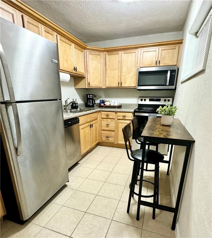 250 Little Street, Unit D107 Athens, GA 30605 - Photo 4 of 20 a kitchen with stainless steel appliances granite countertop a refrigerator a stove a sink and a refrigerator